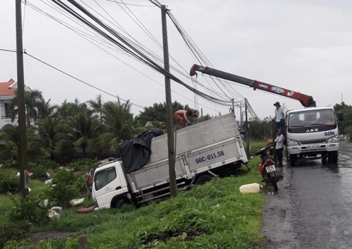 Mưa lớn, hai xe tải mất lái lao xuống kênh