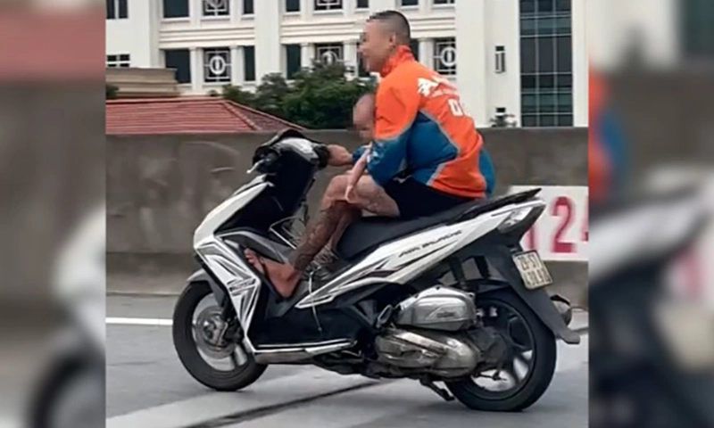 Không mũ bảo hiểm, ôm trẻ trong lòng, phóng xe như bay trên cao tốc