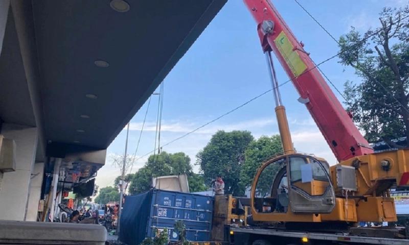 Thùng xe container lật, đè nát xe chở rác